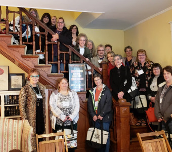 KMA members gather around a historic wooden staircase