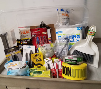 Museum disaster kit featuring trash bags, screwdrivers, drop cloths, cleaning towels, whisk broom and dustpan, goggles, caution tape and more for the live auction.