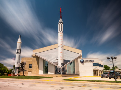 At left a Titan II and center a Redstone launch vehicle from the US space program are front and center with the exertior of the Cosmosphere building behind them.