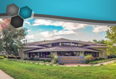 Exterior building view with sign "Museum of Deaf History, Arts & Culture" and green grass in front.