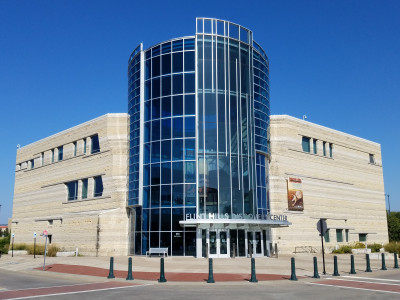 Exterior of the Flint Hills Discovery Center's entrance with curved glass tower and stone building.