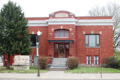 Exterior of the two story red brick Morris County Historical Society building with an arched window over the covered porch with steps and a lightpost in front.