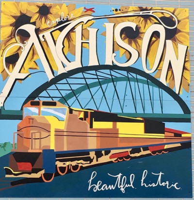 Mural with text "Atchison: beautiful, historic" and featuring sunflowers, an arched bridge, and a train.