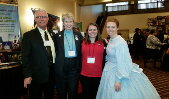 KMA Vice President Bob Workman, Executive Director Lisa Dodson, unidentified member, and member Alexis Radil in 1860s period dress pose at the Travel Industry Association of Kansas' Destination Statehouse. 