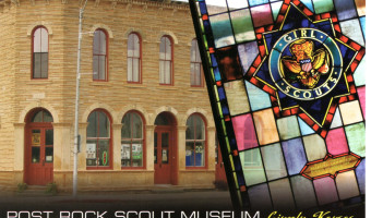 Postcard of the Post Rock Scout Museum, featuring a two story limestone building with arched windows overlaid with a stained glass window with the Girl Scout crest in the middle.