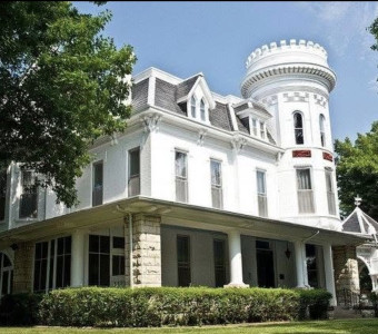 Image of three storey white house with large turret and wrap around porch that is the Evah C. Cray Museum in Atchison