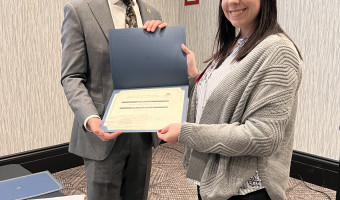 KMA Grant Committee member Trae Johnson, left, hands a grant certificate for the Geary County Historical Society to Lisa Caitlin Highsmith, right.