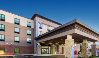 Image of the 4 storey Holiday Inn Express and Suites in Atchison with covered overhang in the foreground.